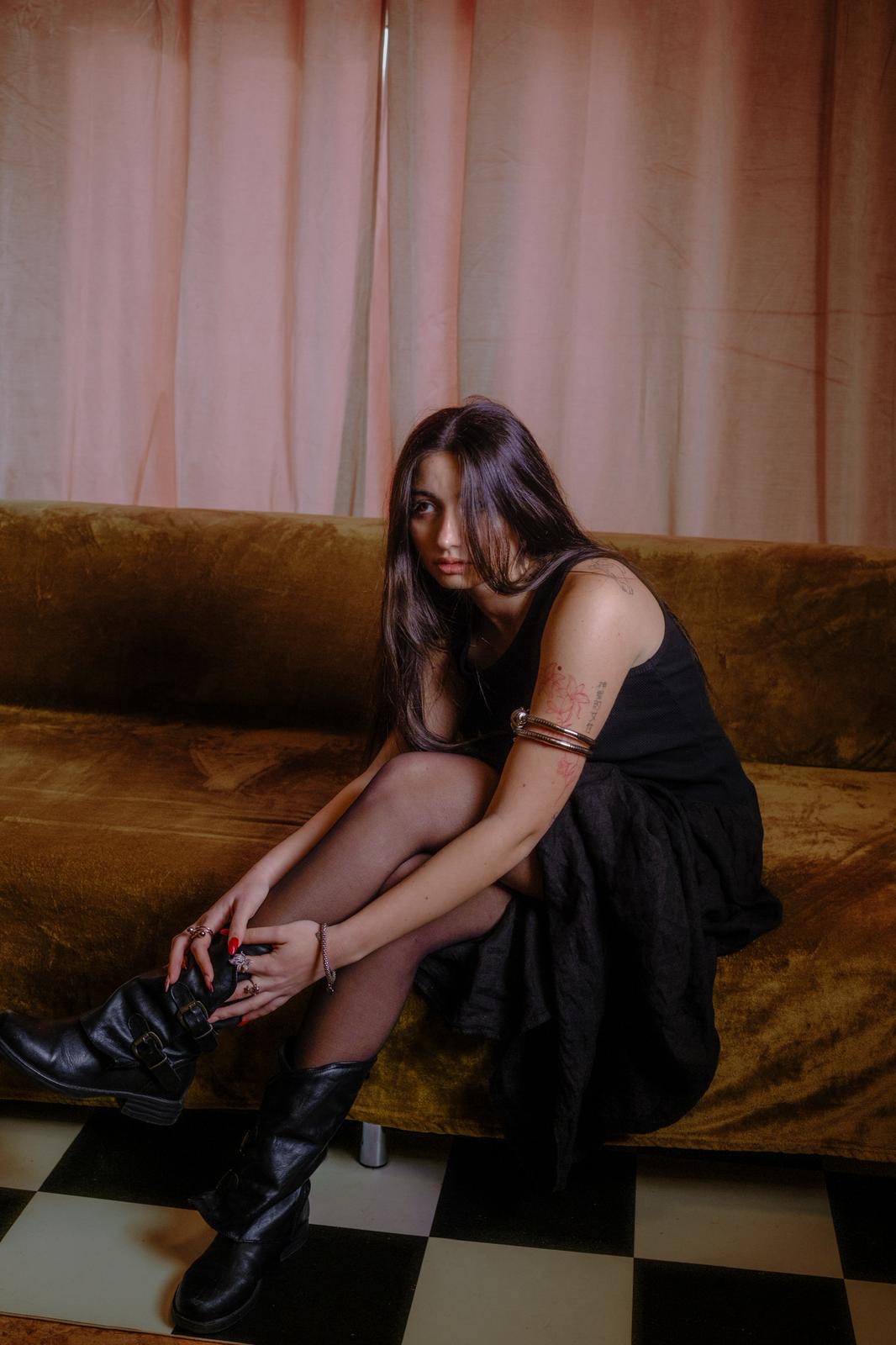 Black dress, croc boots, hand on knee